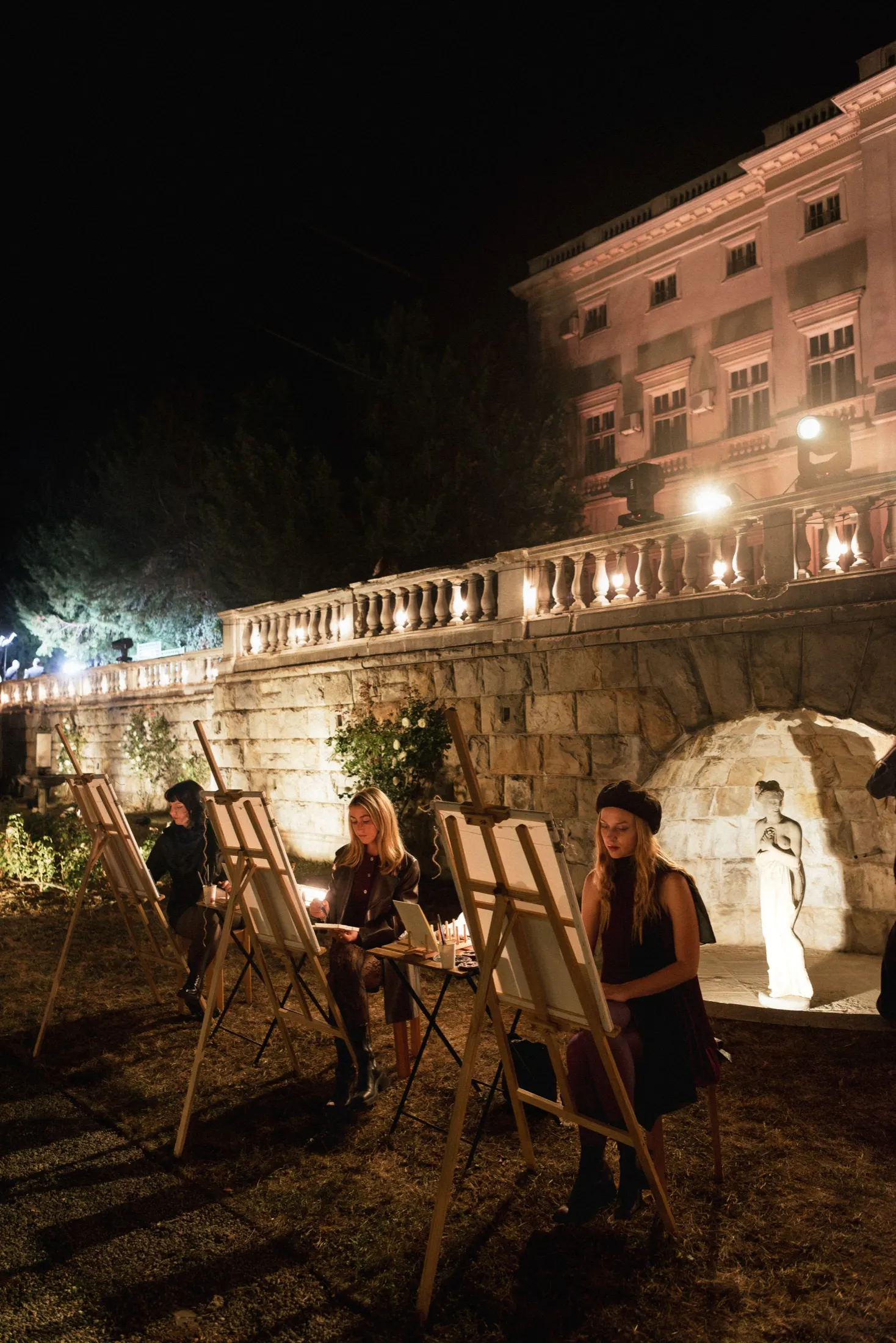 Večernji event na otvorenom sa štafelajima uz kamenu ogradu